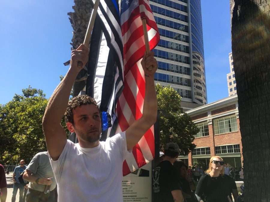 Sacramento resident Matthew Long waives an American flag and Blue Lives Matter flag during the Cop Expo Shut Down at the Sacramento Convention Center Tuesday, Sept. 18. Long said he was there in honor of friend Sacramento County Sheriffs Deputy Mark Stasyuk who was shot and killed Monday, Sept. 17 while on duty. 