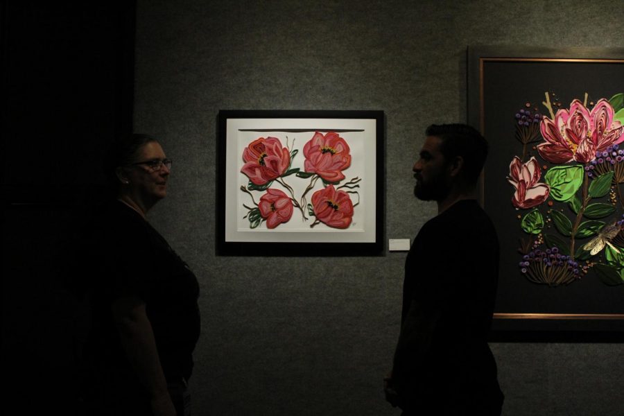 Rebecca Dietzler (left) and Gabriel Alarcon (right) discuss a floral piece at the Spring Delusions exhibit in the University Unions art gallery on Sept. 6