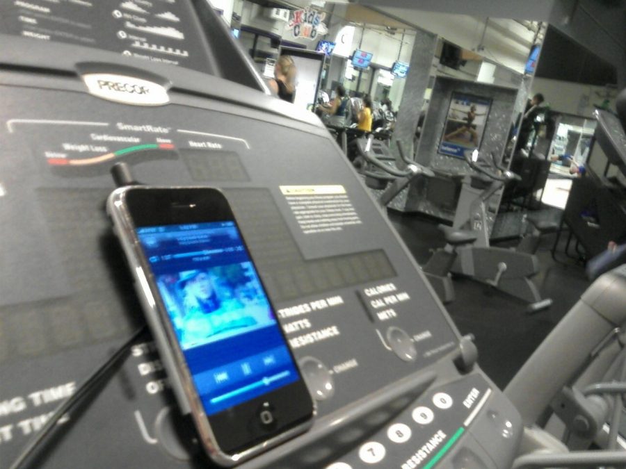 A phone set down on a treadmill at a gym. There isnt a problem with this, except when you end up sitting there using your phone when someone else might want to use that equipment.