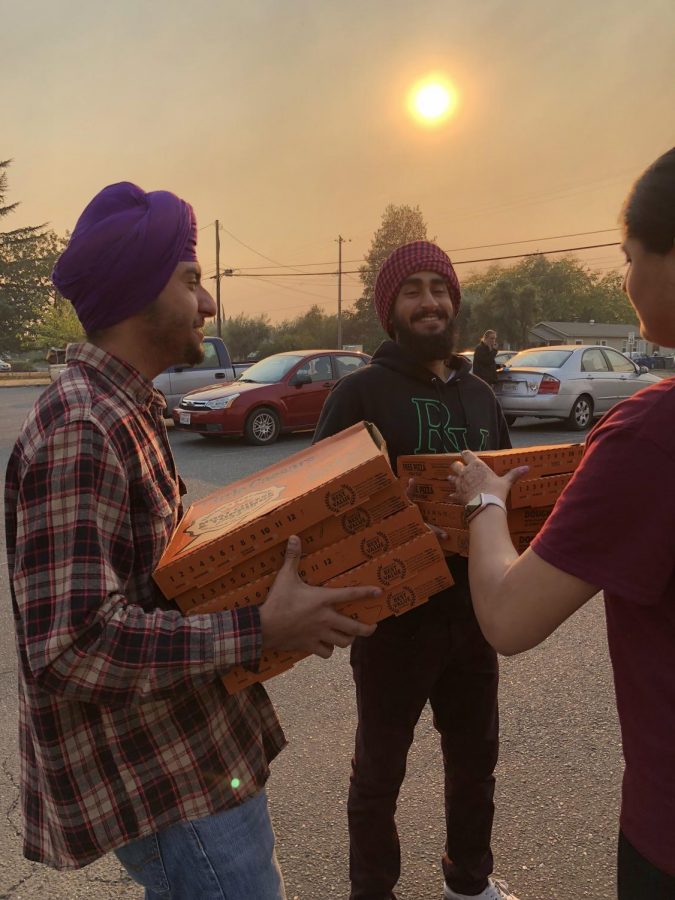 Sacramento State student Harinder Singh, Jasmeet Saroya, and Jaskaran Nijjar collect pizzas to donate to an Oroville church sheltering evacuees Sunday, Nov. 11, 2018.