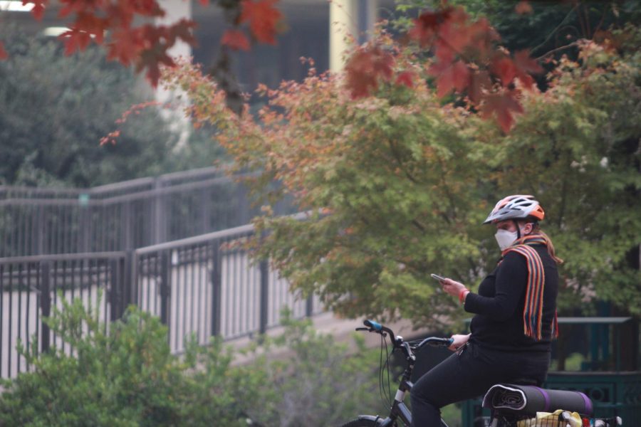 A+female+biker+stops+in+front+of+the+Sacramento+State+library+to+take+photos+of+the+smoke-filled+closed+campus+on+Nov.+14.+