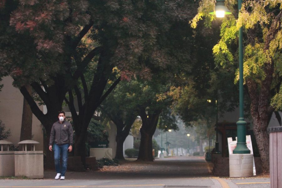 Sacramento State Residence Life Coordinator Edgardo Palomo wears a respirator mask as he treks through the smoke-filled campus walkways on Nov. 14. President Robert Nelsen announced for the third day in a row that campus will be closed Thursday due to the poor air quality from the smoke of the Camp Fire in Butte County.