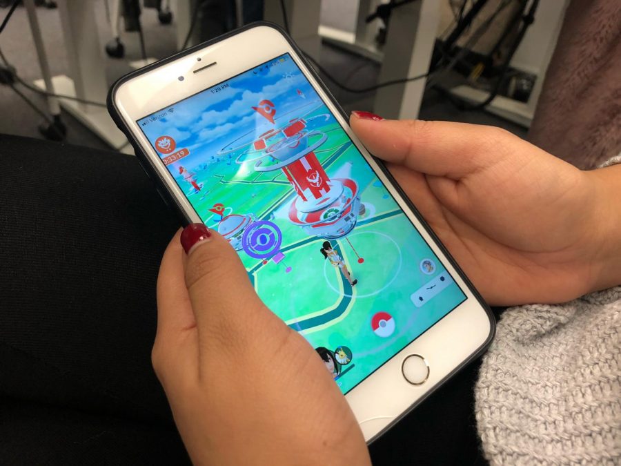 Reyna Flores playing Pokémon GO in the library during a study break on Wednesday, Dec. 5.