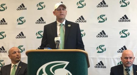 Sac State athletic director Mark Orr (left) and Sac State President Robert Nelsen (right) listen while Troy Taylor speaks during his introductory press conference Dec. 18 at Broad Fieldhouse.