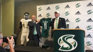 Sac State Athletic Director Mark Orr (left) and new Sac State football coach Troy Taylor hold up a jersey at Taylors introductory press conference Dec. 18 at Broad Fieldhouse.