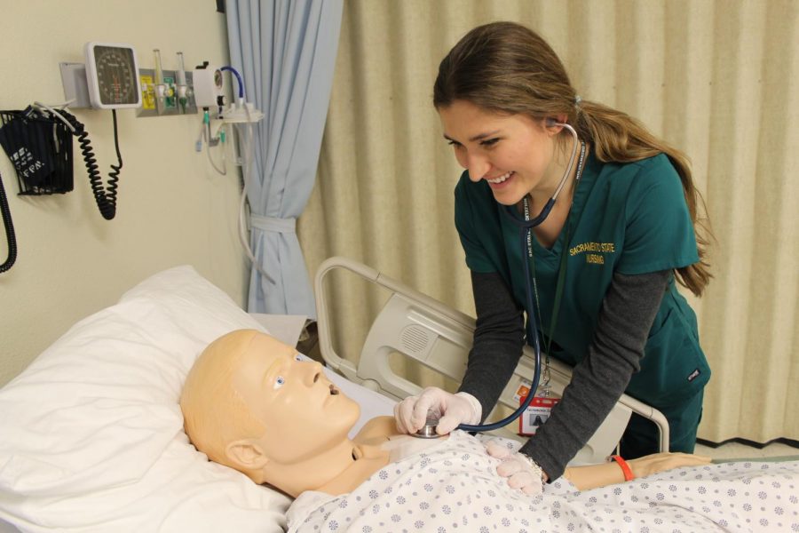 Nursing student, Danielle Baldwin, using a stethoscope on a realistic simulation mannequin in one of Sacramento States laboratories in Folsom Hall. Simulation labs allow nursing students to gain essential skills and a hands on experience. 