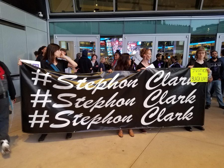 Sacramento State student Manushi Weerasinghe and other protesters hold up a sign protesting the death of Stephon Clark on March 27, 2018 outside of the Golden 1 Center before the Sacramento Kings hosted the Dallas Mavericks.