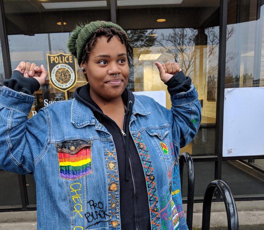 Sac State alumna Breanna Martin shows off an ornate and hand-made coat she attended Tuesdays sit-in with.