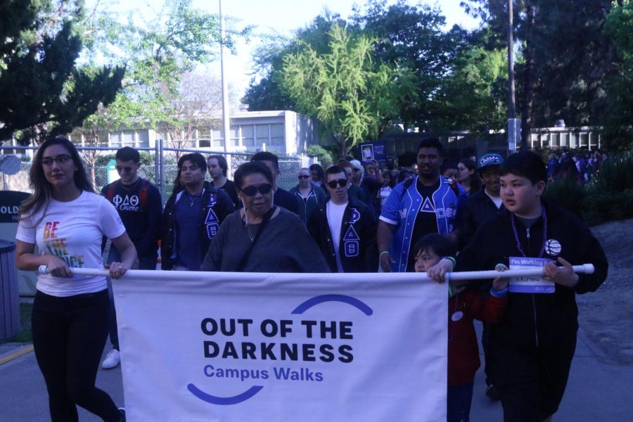 Participants in Sac State's eighth annual Out of the Darkness walk by Humboldt Hall on April 11, 2019.  Participants walked two miles around campus to bring awareness to suicide prevention.