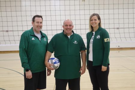 Volleyball coaches Ed Jackson, Ruben Volta and Sarah Chlebana pose for a photo before practice Wednesday, Oct. 23 at Yosemite Hall. Jackson, Volta and Chlebana were all student athletes at Sac State, earning national and conference championships.