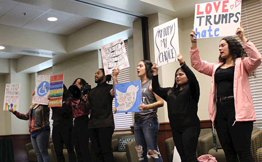 Actors in the production hold signs while chanting during a rehearsal in the University Unions Valley Suite. A Memory, A Monologue, A Rant and A Prayer will be shown in the University Union Ballroom at 7 p.m. on Thursday, Feb. 27.
