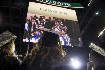 Graduating Sac State students watch themselves on a giant screen inside Golden 1 Center during the commencement procession May 18, 2018. Sac State administration is proposing a virtual commencement in addition to allowing spring 2020 graduates to walk at the spring 2021 commencement.