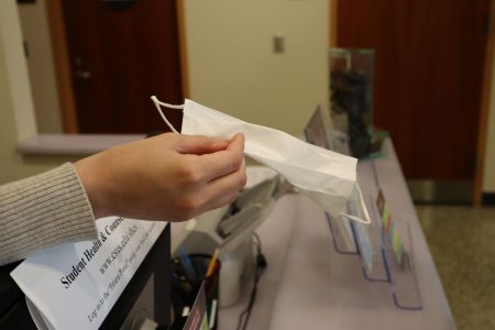 An employee hands out a mask at Sacramento State on March 12.