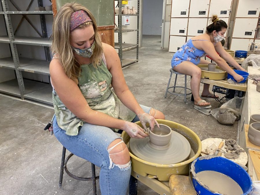 Studio+art+major+Jessica+Wolfe+and+other+advanced+ceramics+students+create+pottery+for+their+next+class+project.+All+students+sit+at+least+six+feet+away+from+each+other+at+their+pottery+wheels+during+class.