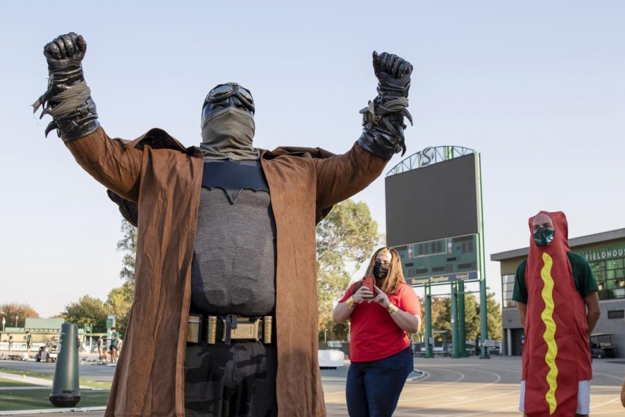 Kyle Lillie, throws coach, dressed as Batman, poses for a photo at the track and field Halloween costume contest at Hornet Stadium Friday, Oct. 30, 2020. The throwers and Coach Lillie dressed as superheroes and everyday heroes.