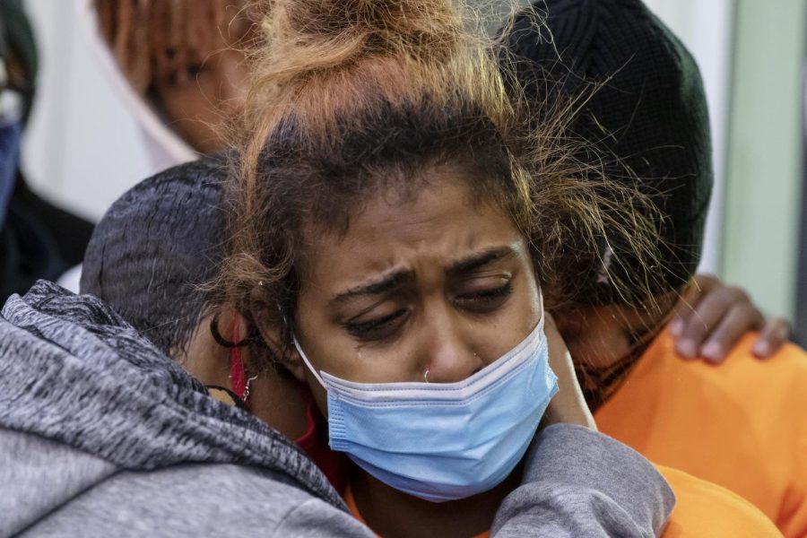 Jamilia Land, left, founder of A.S.A.P. (Anti-Violence, Safety and Accountability) and family spokesperson, consoles Jayda James, center, and Dwayne James, parents of Sa’Quan Reed-James, 17, and Dewayne James Jr., 19, during the candlelight vigil at Arden Fair Mall in Sacramento, California, Tuesday, Dec. 1, 2020. The James brothers were shot and killed at the exit by Forever 21 on Black Friday. 