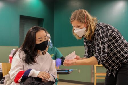 (File photo) Rachel McMichael, nurse practitioner at the WELL, verifies the identity of Rica Co, second semester nursing student, before injecting her with the COVID-19 vaccine in the Brown Bag room in the Union on Thursday, Jan. 28, 2021. 