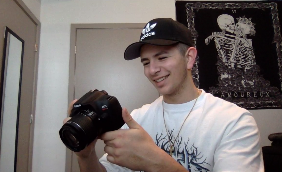Jesús Rivas looks at a picture he took on his Canon camera in his apartment bedroom on Feb. 25, 2021. Rivas, in his spare time, said he likes to capture moments on his camera as a way to let his creativity out during isolation.