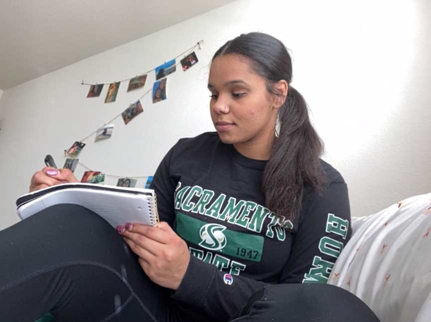 Michelle Guilford, a communication studies major with a minor in deaf studies, writes in her personal journal in her apartment bed on Feb. 26, 2021. Guilford said she writes in her journal every other day to reflect and get things off her chest. 