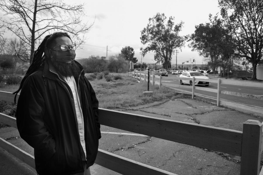 Charles Joseph walks to the edge of his apartment complex’s parking lot to his favorite spot to watch life unfold on Wednesday, March 10, 2021 in Sacramento, California. His scenery from here includes an old wilted oak tree, an empty field that used to be apartments and a Dutch Bros coffee shop with a constantly filled drive-thru line. 