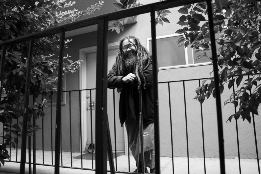 Charles Joseph stands outside of his second story apartment next to trees growing in between two apartment buildings Wednesday, March 10, 2021 in Sacramento, California. Joseph said that he enjoys how calm and peaceful his apartment is after years of living in prisons and detainment centers. 