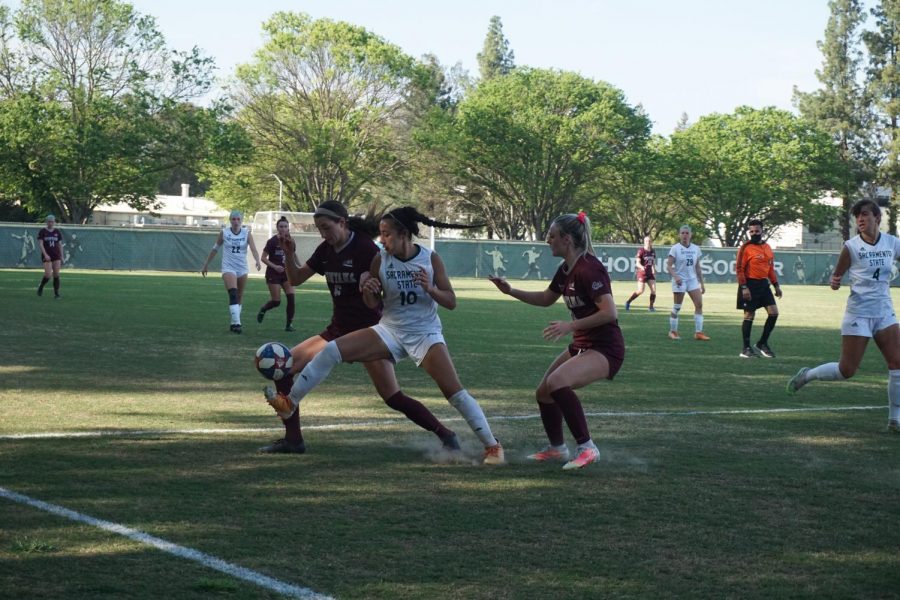 Senior forward Tiffany Miras kicks toward the sidelines as two Montana players fight for control of the ball during the game at Sac State on Friday, April 2. The game was the first Sac State athletic event  to feature fans in attendance, at 20% capacity. 
