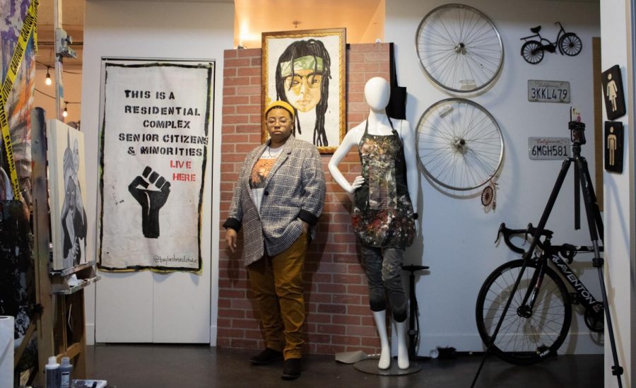 Artist Taylor Pannell stands next to a mannequin and in front of a self portrait inside her art studio Taylor’d Mind Studios in Sacramento on Feb. 3, 2021. The self-portrait is made from coffee watercolor and ink.