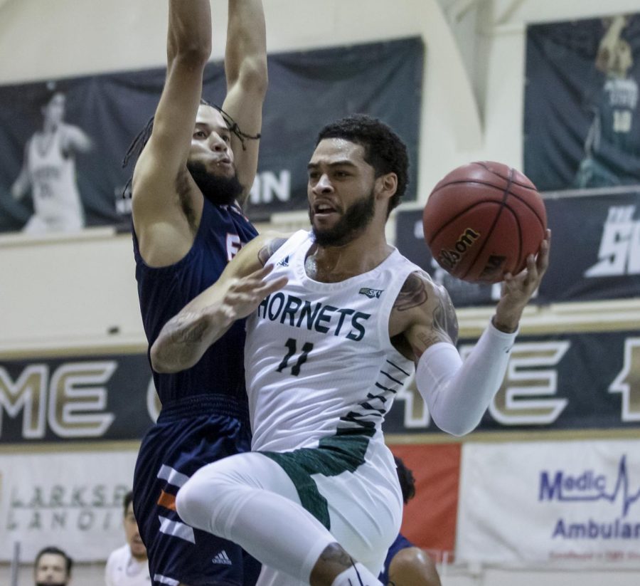 Sacramento State’s Brandon Davis (11) passes the ball around Fresno Pacific A.J. Kirby (3) during the second half in the non-conference game at the Nest at Sac State in Sacramento, California, Jan. 3, 2021. Davis is going pro overseas to be the newest point guard to be signed onto the Mets de Guaynabo basketball team.
