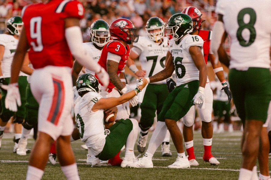 Sacramento State Tight End Marshel Martin (16), helps his quarterback Asher OHara up at end of the play. OHara connected with Martin twice to give the Hornets their only two touchdowns of the game against Dixie State University Saturday, Sept. 4, 2021. 
