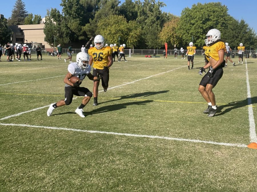 Sacramento State senior wide receiver Dewey Cotton catches a pass as he attempts to score against the opposing defense in practice. The Hornets prepare for their season debut against Dixie State this Saturday, Sept. 4, 2021. 
