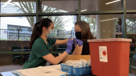 (File photo) Nursing student Carmel Stewart (right) receives her first dose of the Pfizer COVID-19 vaccine in the Brown Bag Room of the University Union on Thursday, Jan. 28, 2021. The State Hornet compiled answers to frequently asked questions about the vaccine mandate and other COVID-19 safety protocols at Sac State.