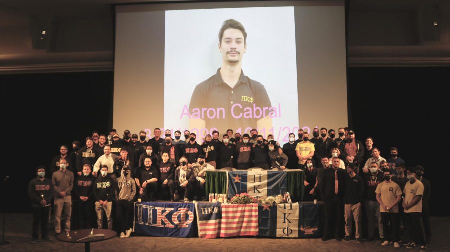 Current and former members of Pi Kappa Phi pose in front of a screen projecting Cabral’s photo Thursday, Oct. 14, 2021. The fraternity held a candlelight vigil where members spoke about their memories with Cabral.