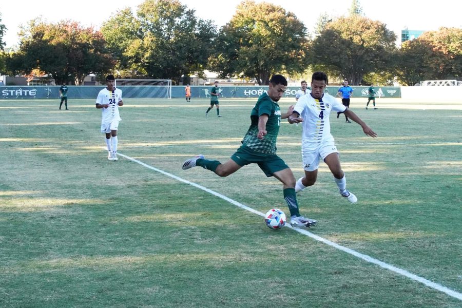 Sacramento State sophomore forward Christo Cervantes (left) shoots while UC San Diego sophomore defender Adam Walker (right) defends during a soccer game on Oct. 16, 2021, at Hornet Field. Sac State won the game 2-1 and will now stay in the postseason race for the Big West tournament, according to head coach Michael Linenberger. 
