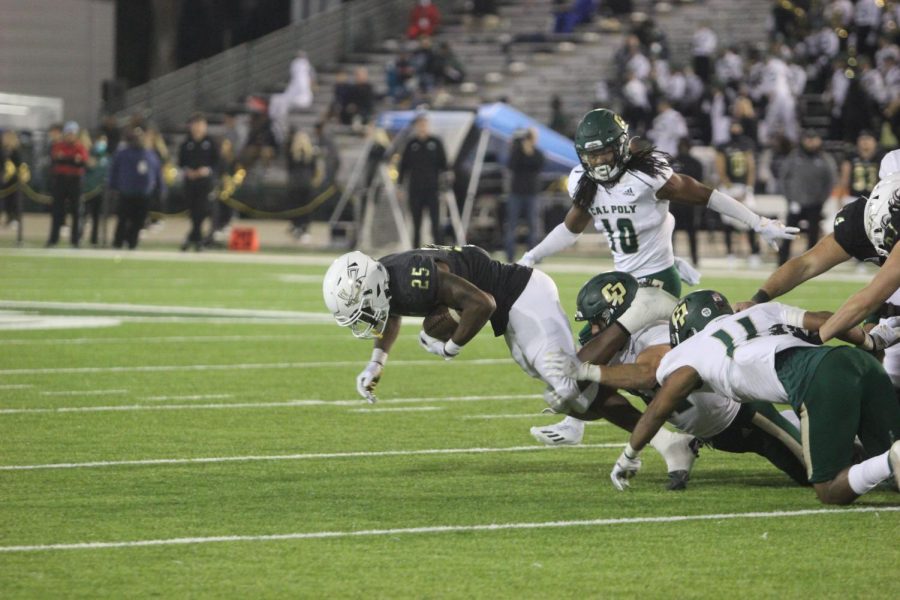 Sac State running back Elijah Tau-Tolliver (25) gets tackled after a run against Cal Poly at Hornet Stadium on Nov. 6, 2021. The Hornets’ offense rushed for 195 yards on the night en-route to a blowout 41-9 victory over the Mustangs.