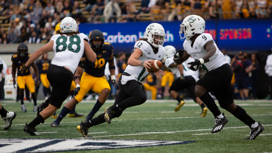 Sac State junior quarterback Jake Dunniway (12) hands off to sophomore running back Marcus Fulcher (9) in the first half at California Memorial Stadium on Saturday, Sept. 18, 2021. Dunniway and his teammate O’Hara would share snaps throughout the game. 