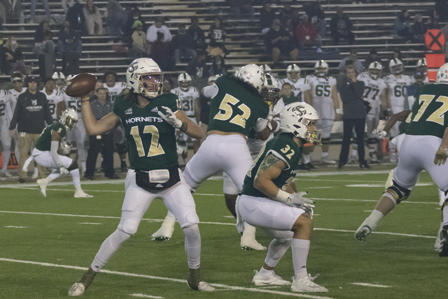 Junior quarterback Jake Dunniway (12) throws to his right with freshman running back Cameron Skattebo (32) blocking in front at Hornet Stadium on Nov. 13, 2021. The Hornets beat the Portland State Vikings 49-20 for their seventh consecutive win. 