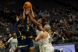 Sophomore center Isnelle Natabou gets swarmed by defenders while grabbing a rebound during both Sacramento State’s and UC Davis’ women’s teams’ first ever Causeway Classic at the Golden 1 Center on Nov. 23, 2021. Sac State womens basketball loss to UC Davis 75-46.
