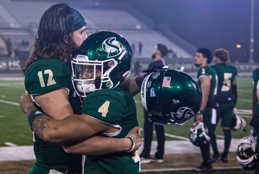 Junior quarterback Jake Dunniway (12) and senior wide receiver Isaiah Gable (4) embrace after losing to South Dakota State on Saturday, Dec. 4, 2021. The Hornets hosted a second-round playoff game against the Jackrabbits.