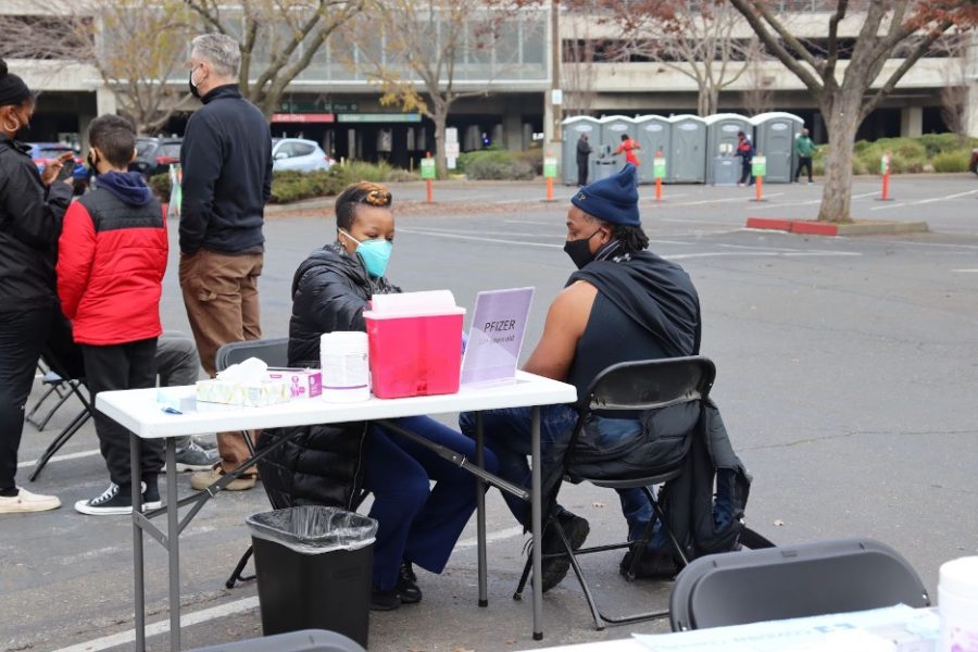 An attendee of the Reclaim MLK parade receives a COVID-19 vaccination in front of the Hornet Stadium at Sac State, Jan. 17, 2022. COVID-19 testing and vaccination options have not been easily accessible to every individual, so Black Lives Matter Sacramento and NAACP of greater Sacramento organized a center to provide them free of charge.