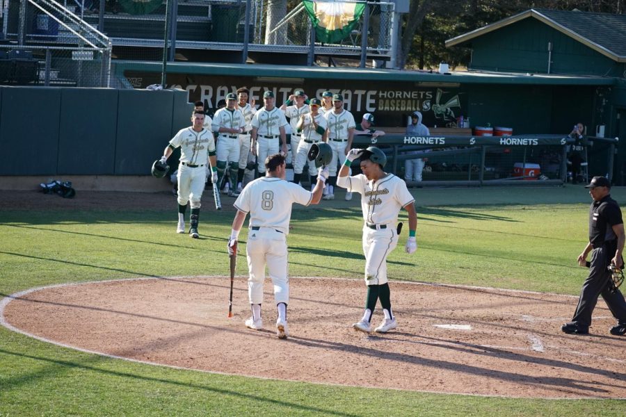Senior third baseman Steven Moretto(left) and sophomore outfielder Cesar Valero(right) tap helmets to celebrate Valero’s homerun on Feb. 18, 2022 against Northern Illinois University at John Smith Field. in a 11-7 Sac State victory. Both Moretto and Valero homered in the Hornets’ opening day of the 2022 season, which helped them achieve an 11-7 victory.