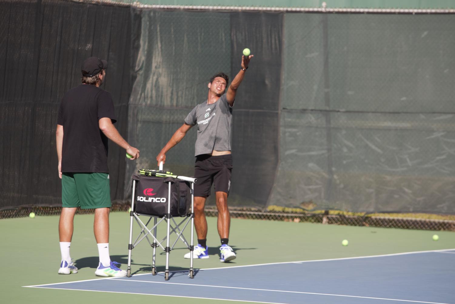  Sac State Sophomore Mark Keki practices his serves with Assistant coach Mikus Losbergs, Wednesday, Feb. 9, 2022. Keki and his sophomore partner Mate Voros are 5-0 In Doubles team matches. 
