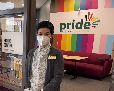 Tranh Pham, the Pride Center coordinator poses in front of the Pride Center entrance on Feb 25. “When students come in here, it is a delight and privilege to be trusted to share that journey,” Pham said. Photo by: Hannah Asuncion

