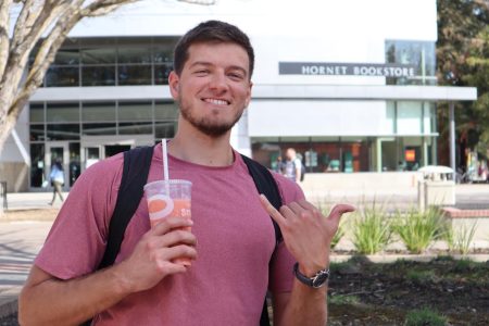 David Yaikov, a senior business major, poses in front of the Hornet Bookstore excited to be back on campus, on Tuesday, March 1, 2022. Yaikov says he is happy that more students are on campus at Sac State this semester. (Photo by Tyra Green)
