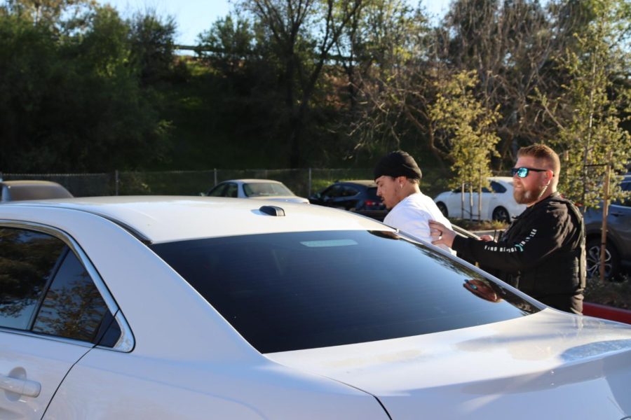 An officer leads the suspect of the high-speed chase into the back of a cop car after being arrested outside the Hornet Commons on Wednesday, March 9, 2022. The car involved in the chase drove through the campus of Sac State before being cornered by police at the Hornet Commons.