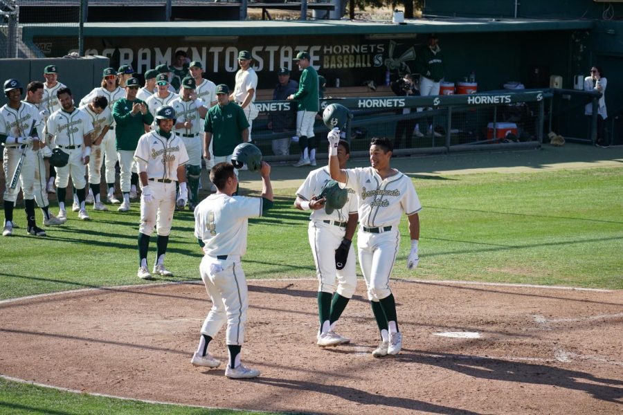Sophomore outfielder Cesar Valero celebrates with teammates freshman outfielder Jeffrey Heard and senior infielder Nick Iwasa in a 21-4 win over Houston Baptist University at John Smith Field on March 4. 2022. Valero’s 10 RBIs was a school record for Sac State.