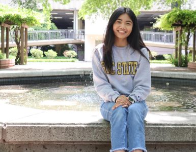 Communications studies major Charlene Francisco poses in front of the water fountain on the library quad on Friday, April 22, 2022. Francisco spent the day promoting the Christian Brotherhood International club that she is a member of. 