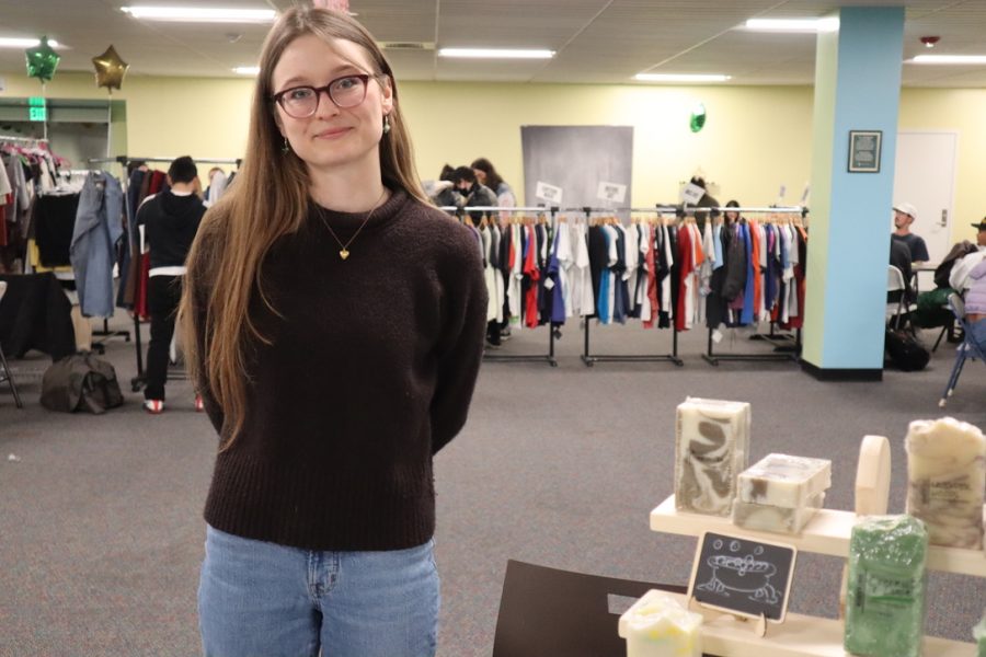 Raven Vance, an anthropology major in her junior year, stands next to her soap and bath products at the Stinger Expo on Tuesday, May 10, 2022. Vance said that while bath bombs are usually the top sellers, her bar soaps were her most popular item at the event. 