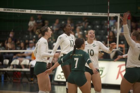 The Sac State volleyball team celebrates near the net after scoring against Idaho State Saturday, Sept. 24, 2022, at The Nest. The Hornets got out to a 2-0 start in Big Sky conference play after a 3-0 victory against the Bengals. 