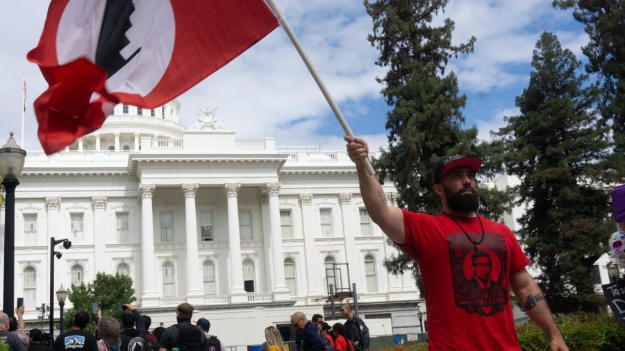 Berkley chef, Sergio Manleón waves UFW flag near the capitol building steps on Sept. 21, 2022. Manleon is one amongst multiple supporters who have traveled to Sacramento to support the United Farm Workers. 