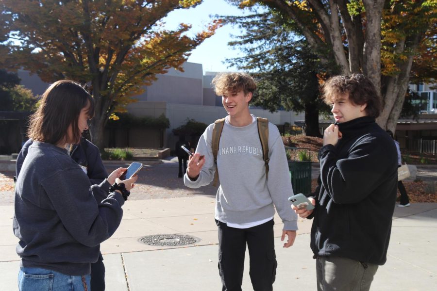 Content creator John Rusanov and his cameraman, second-year business major Eric Shambra, interact with fourth-year biological science student Audrey Dakis while filming a TikTok video outside the Bookstore on Nov. 18. Rusanov has been filming his videos at Sacramento State for about six months. 